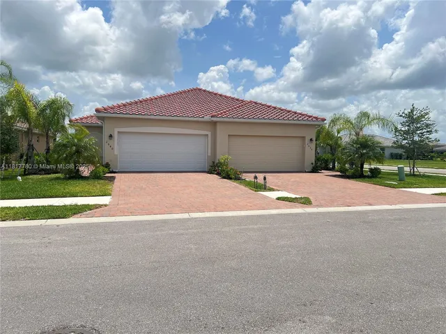 a view of a house with a yard and large tree