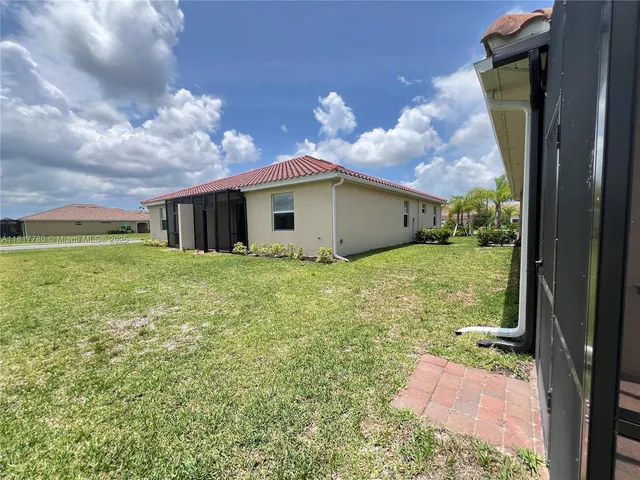 a backyard of a house with table and chairs