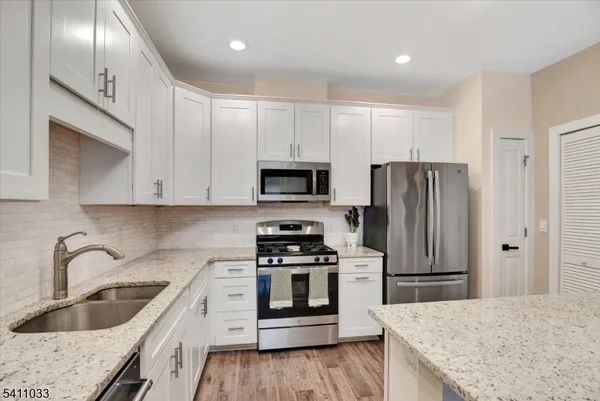 a kitchen with stainless steel appliances granite countertop a refrigerator stove and sink