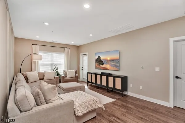 a living room with furniture and a wooden floor