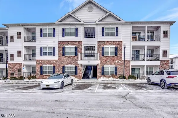 a front view of a residential apartment building with a yard