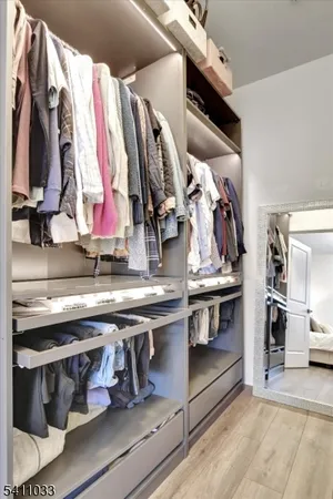a view of walk in closet with clothes and shoes