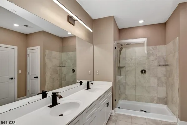 a bathroom with a shower a sink and a mirror