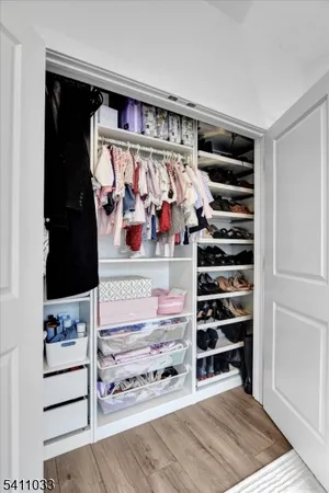 a view of walk in closet with clothes and shoes