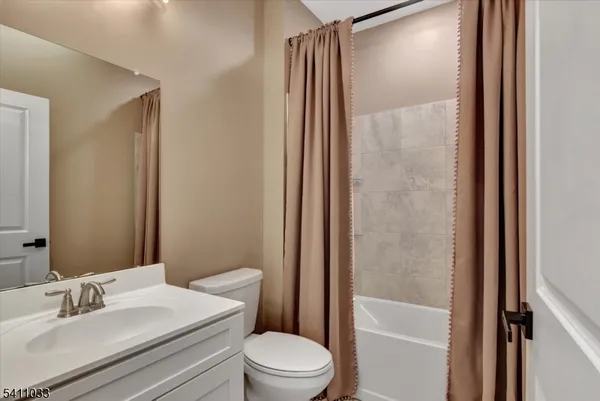 a bathroom with a sink a toilet a mirror and shower