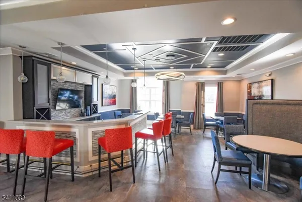 a kitchen with stainless steel appliances granite countertop a table chairs and a wooden floor