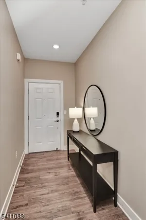 a view of a hallway with wooden floor and white walls