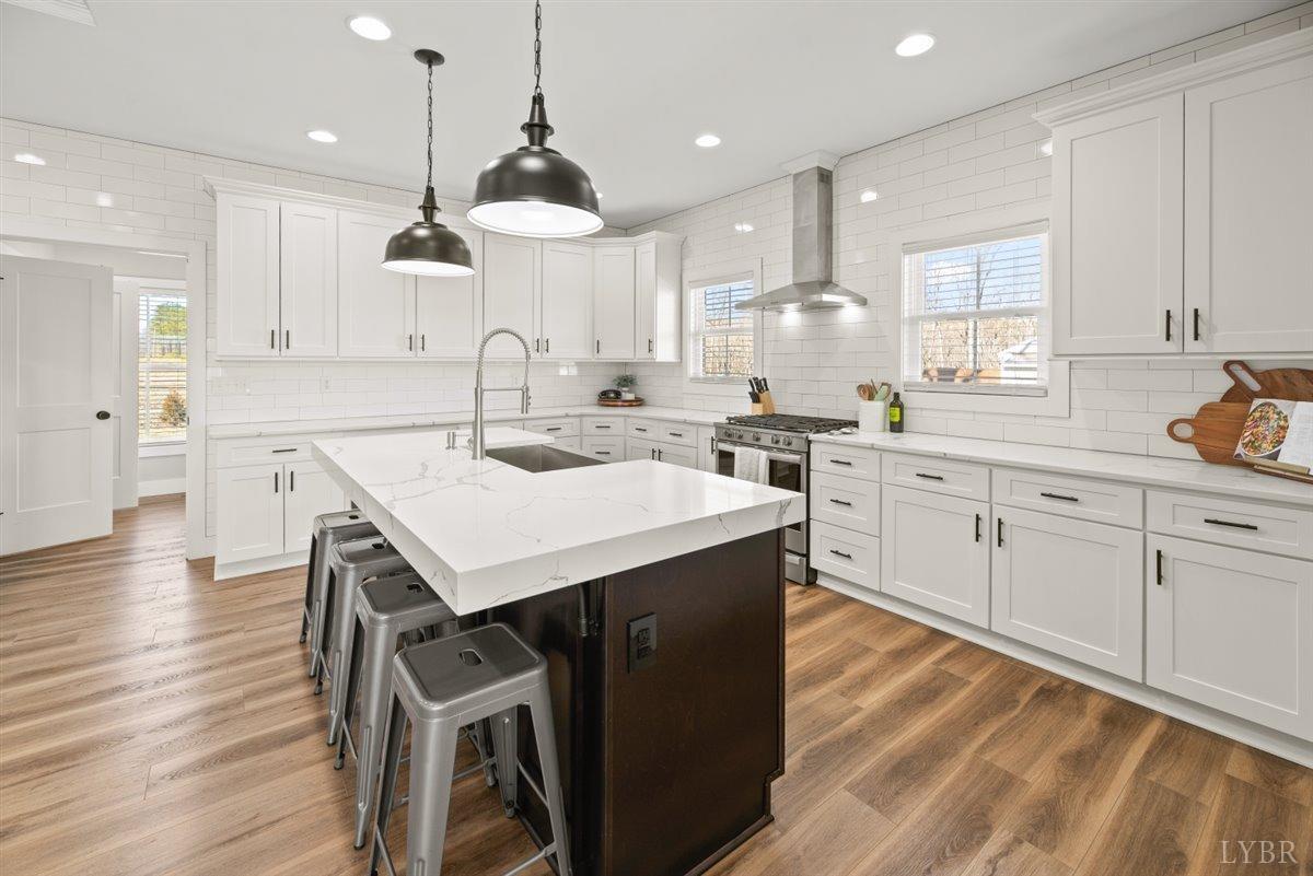 4639 Lowry Road Goode, VA 24556 - Photo 7 of 76 a kitchen with a stove a sink a dining table and chairs