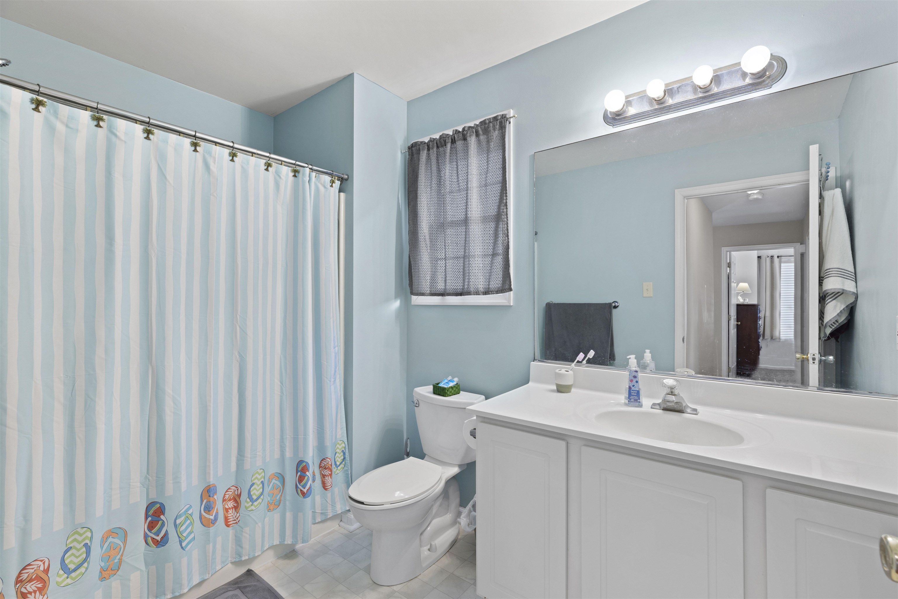 512 West Andrews Avenue, Unit B Wildwood, NJ 08260 - Photo 17 of 25 a bathroom with a sink a toilet and a mirror