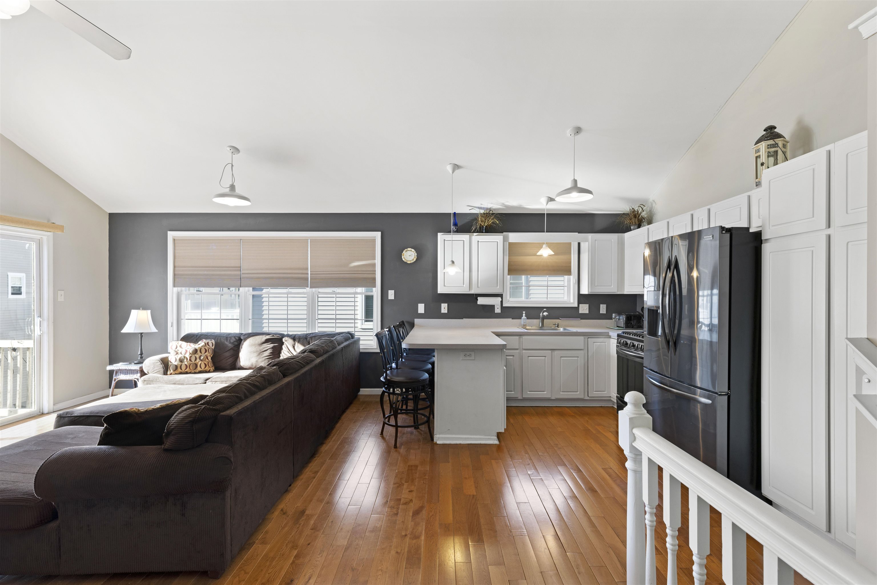 512 West Andrews Avenue, Unit B Wildwood, NJ 08260 - Photo 10 of 25 a large open kitchen with a refrigerator a stove top oven a large window with wooden floor and cabinets
