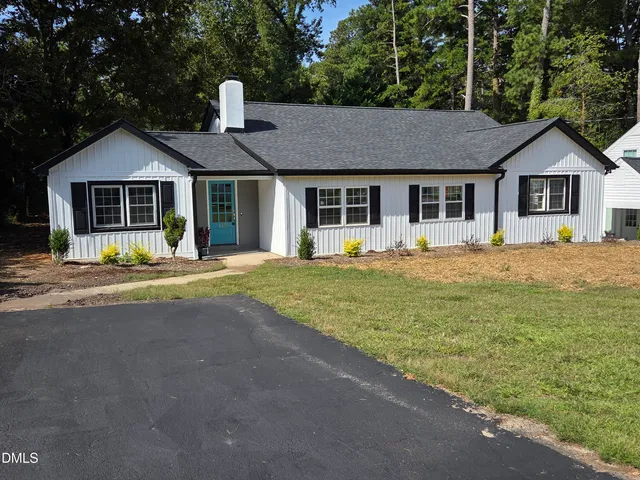 a front view of a house with a yard and trees