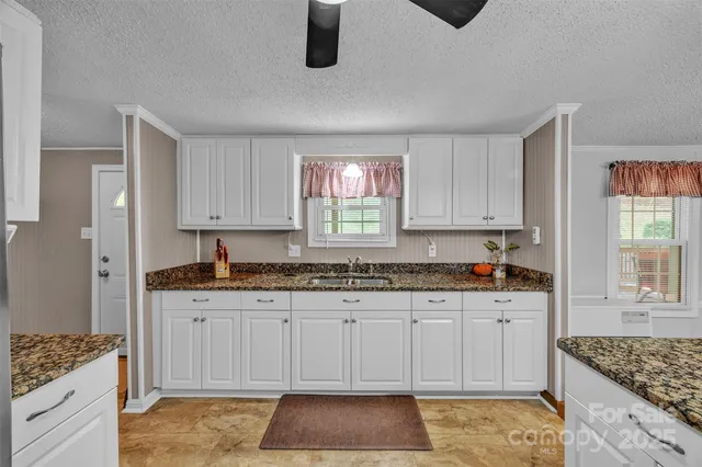 a kitchen with granite countertop a sink and a stove