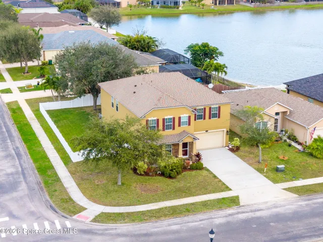 an aerial view of a house with swimming pool and lake view