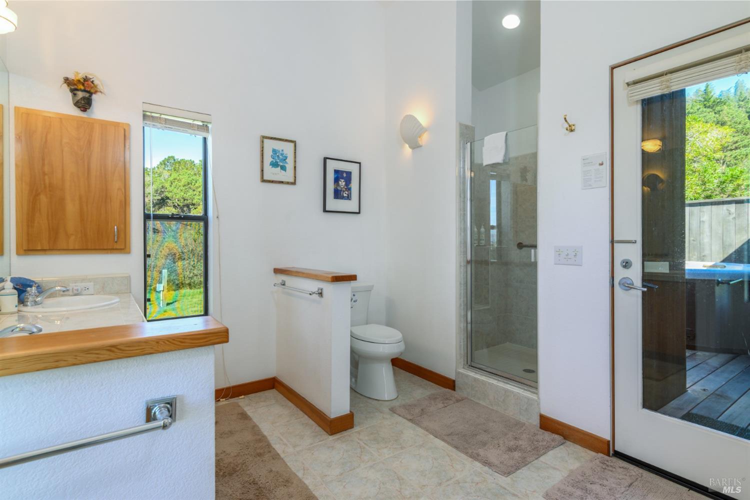 39722 Leeward Road, Unit 28 The Sea Ranch, CA 95497 - Photo 14 of 30 a bathroom with a granite countertop toilet a sink and a mirror