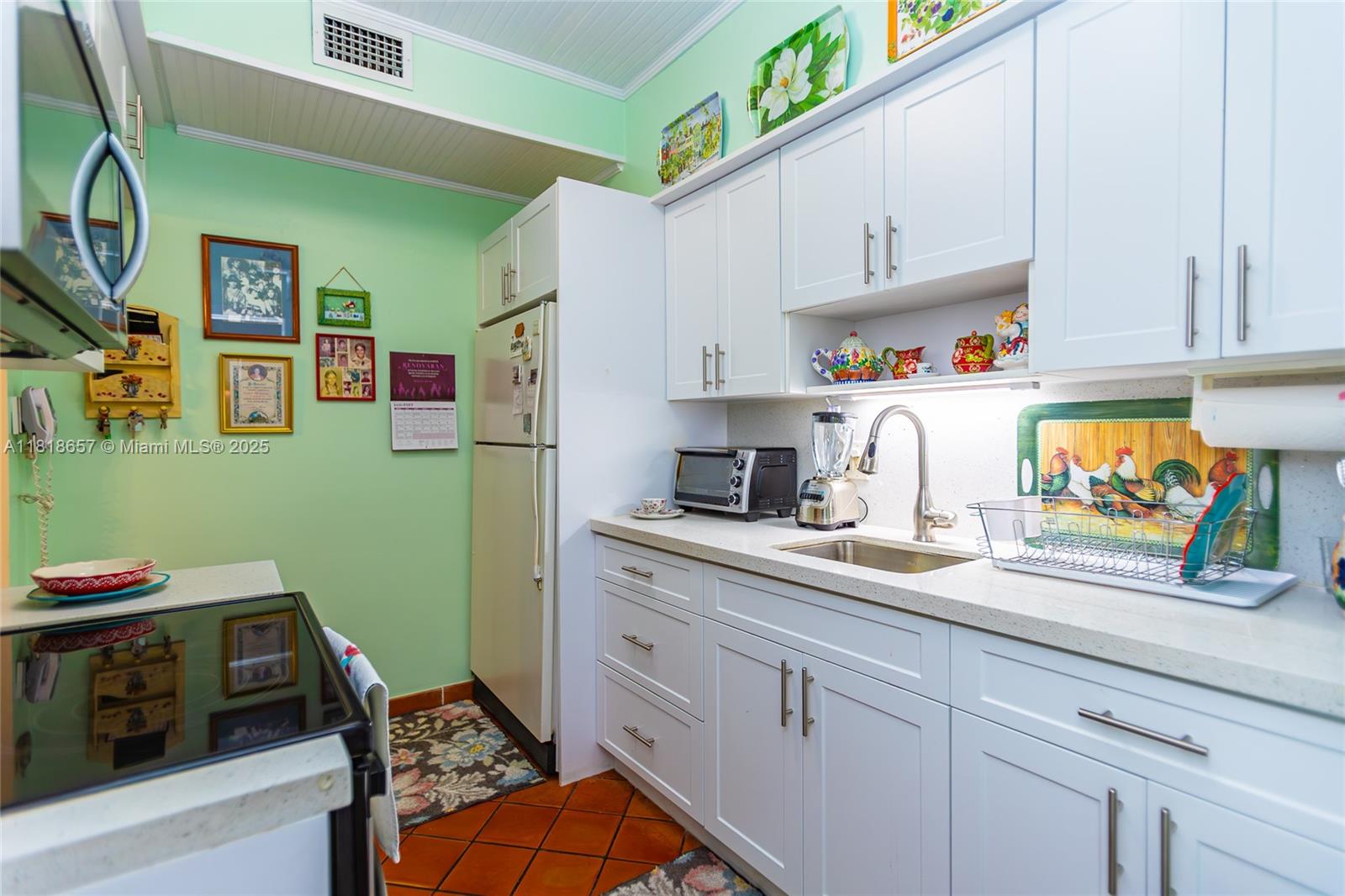 7110 Southwest 13th Terrace Miami, FL 33144 - Photo 22 of 48 a kitchen with stainless steel appliances white cabinets and a refrigerator