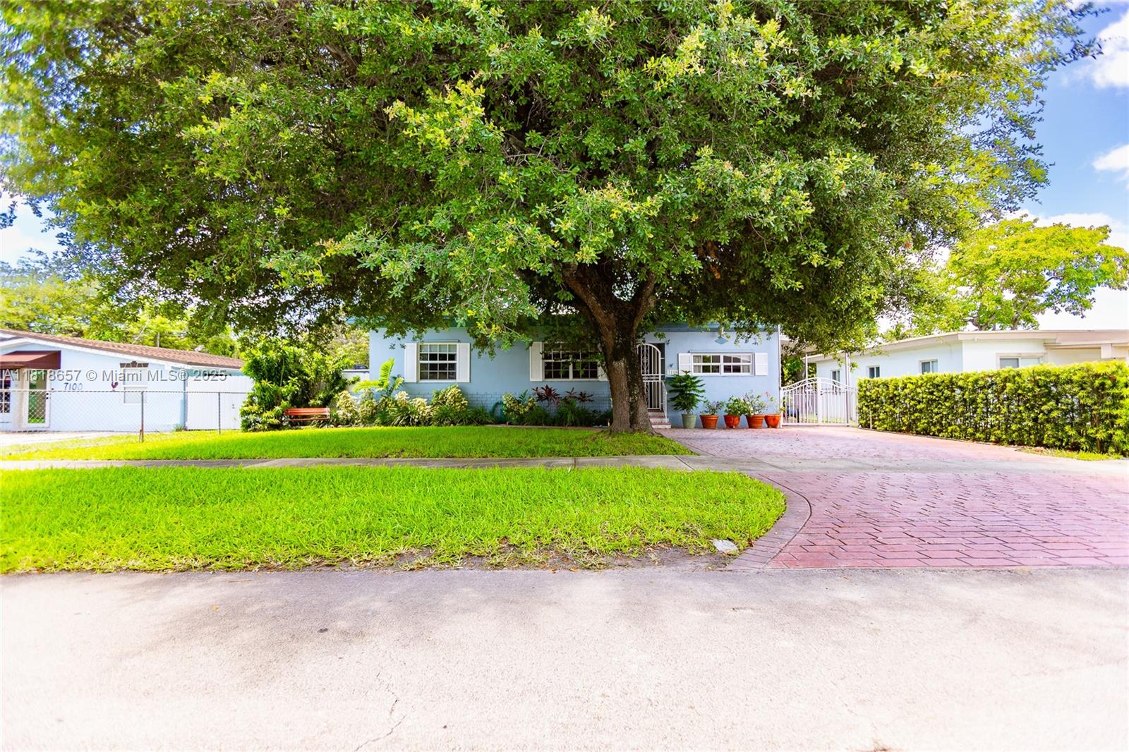 7110 Southwest 13th Terrace Miami, FL 33144 - Photo 7 of 48 a white house that has a tree in front of it