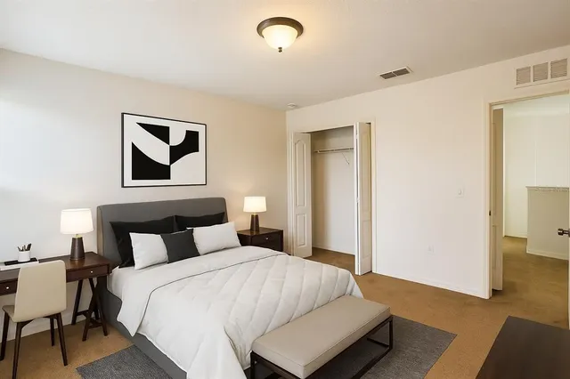 a view of an empty room with closet and wooden floor