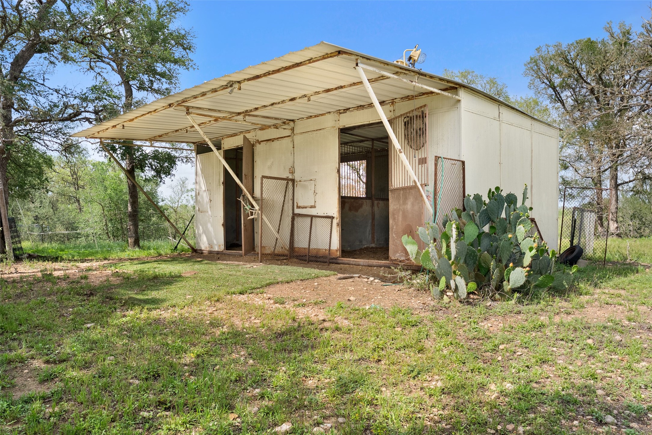 274 Old Austin Trail Elgin, TX 78621 - Photo 10 of 32 a view of a white house next to a yard with plants and trees