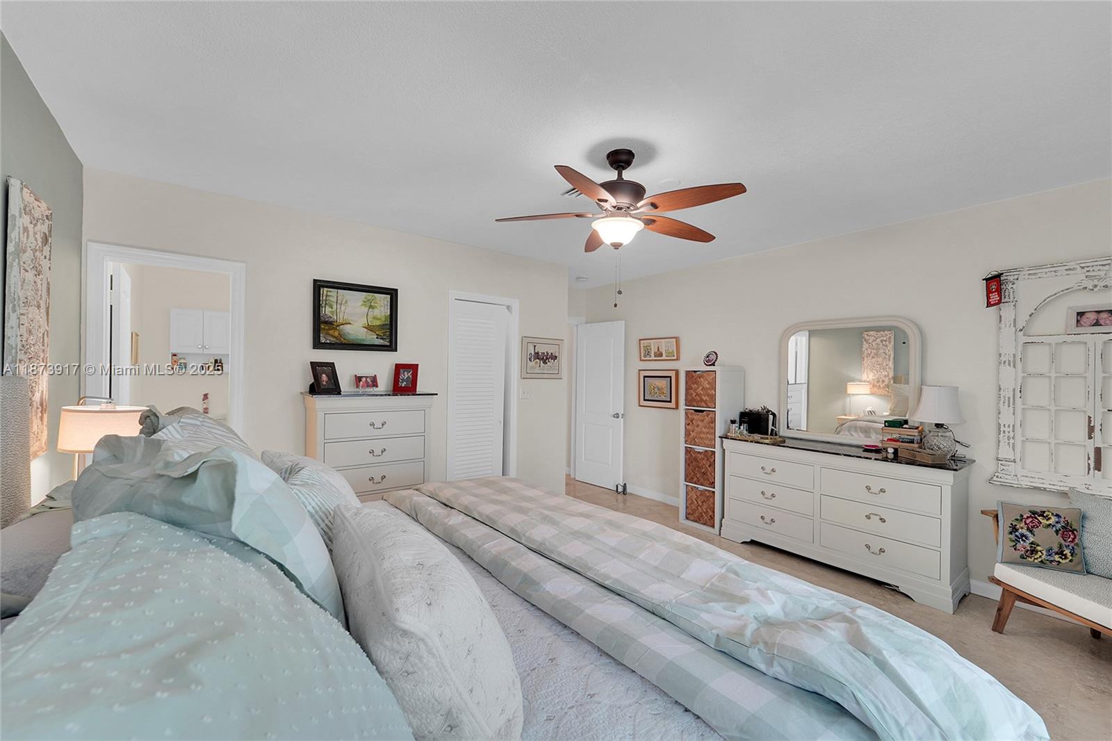 1431 South Ocean Boulevard, Unit 11 Lauderdale-by-the-Sea, FL 33062 - Photo 21 of 42 a spacious bedroom with a bed and a chandelier