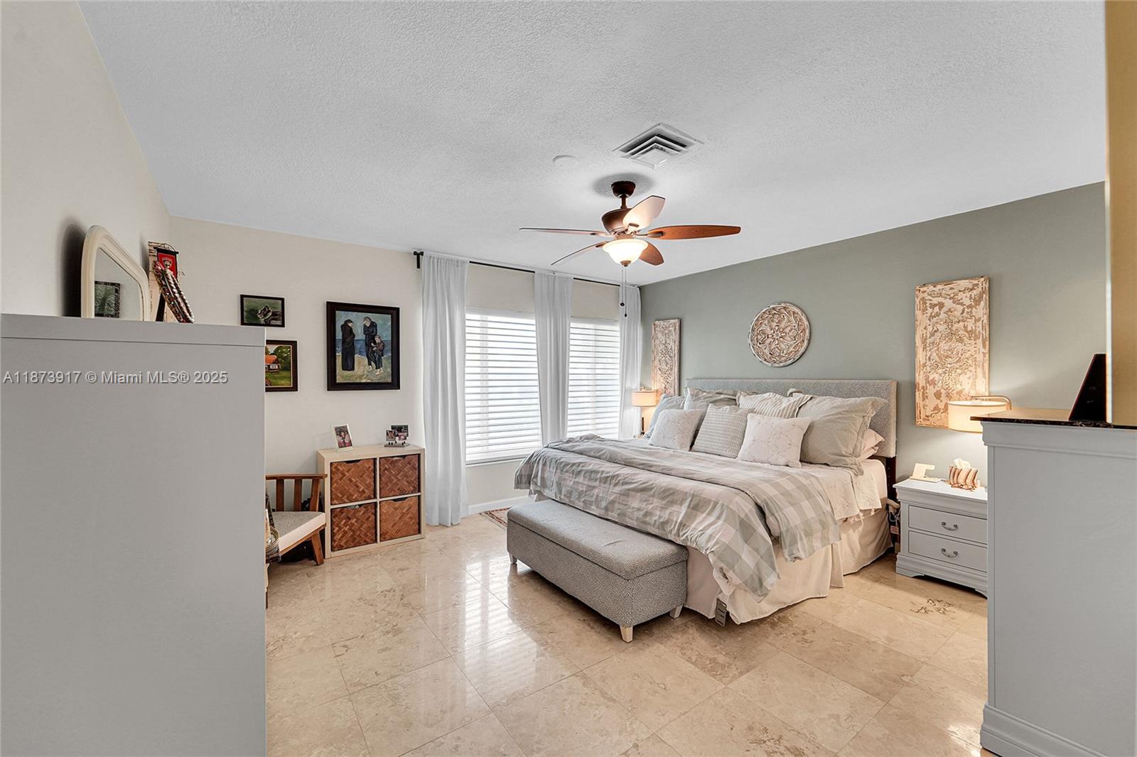 1431 South Ocean Boulevard, Unit 11 Lauderdale-by-the-Sea, FL 33062 - Photo 22 of 42 a spacious bedroom with a bed and a chandelier