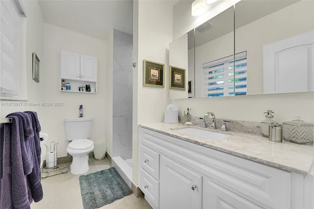 a bathroom with a granite countertop toilet sink and a mirror