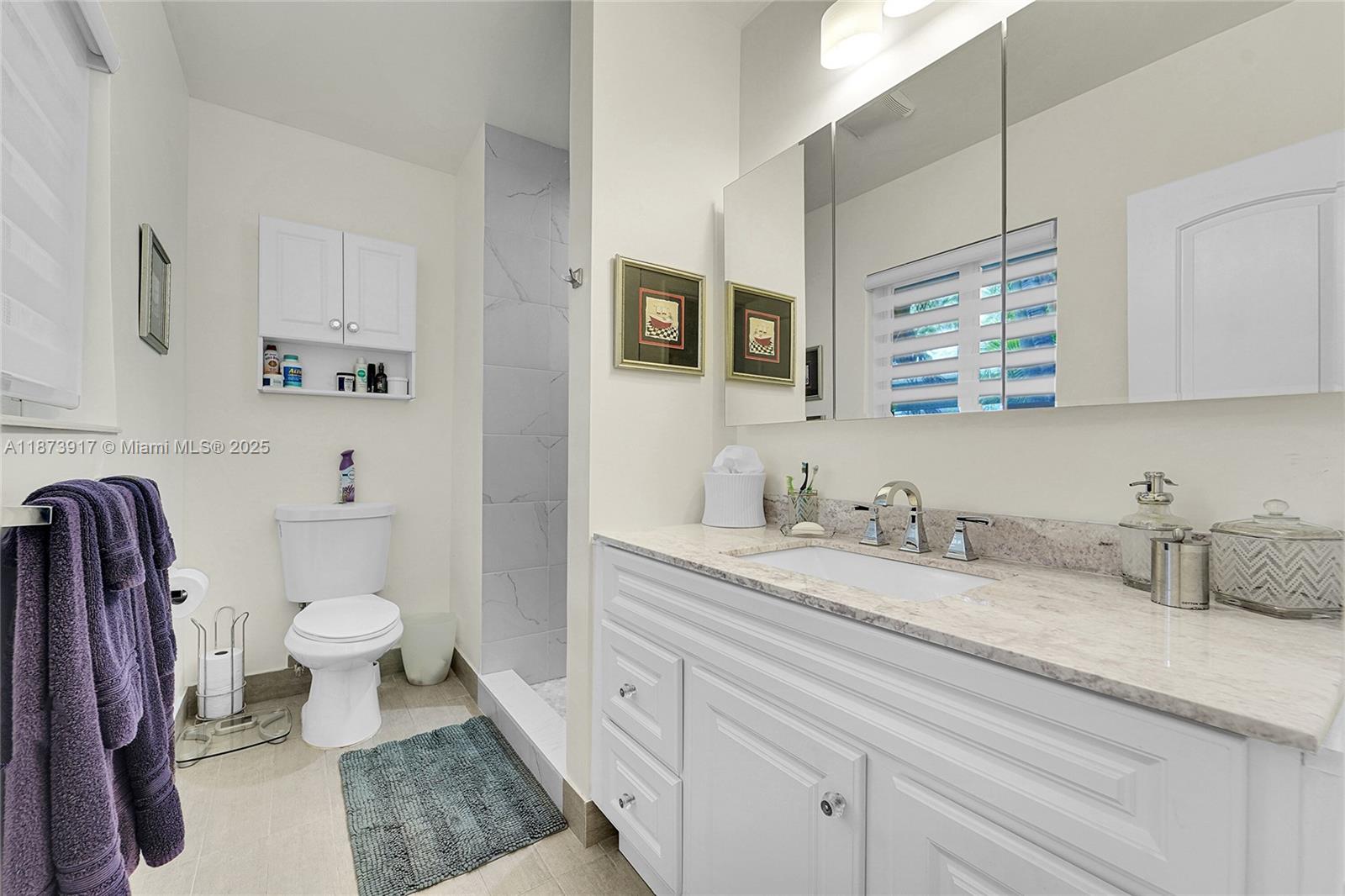 1431 South Ocean Boulevard, Unit 11 Lauderdale-by-the-Sea, FL 33062 - Photo 24 of 42 a bathroom with a granite countertop toilet sink and a mirror