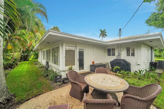 a view of a house with backyard sitting area and garden