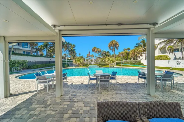 a view of a patio with a table chairs and a floor to ceiling window
