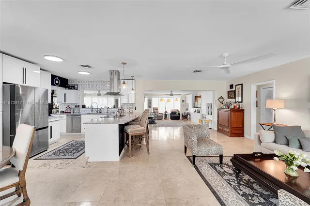 a kitchen with stainless steel appliances kitchen island granite countertop a stove refrigerator and cabinets