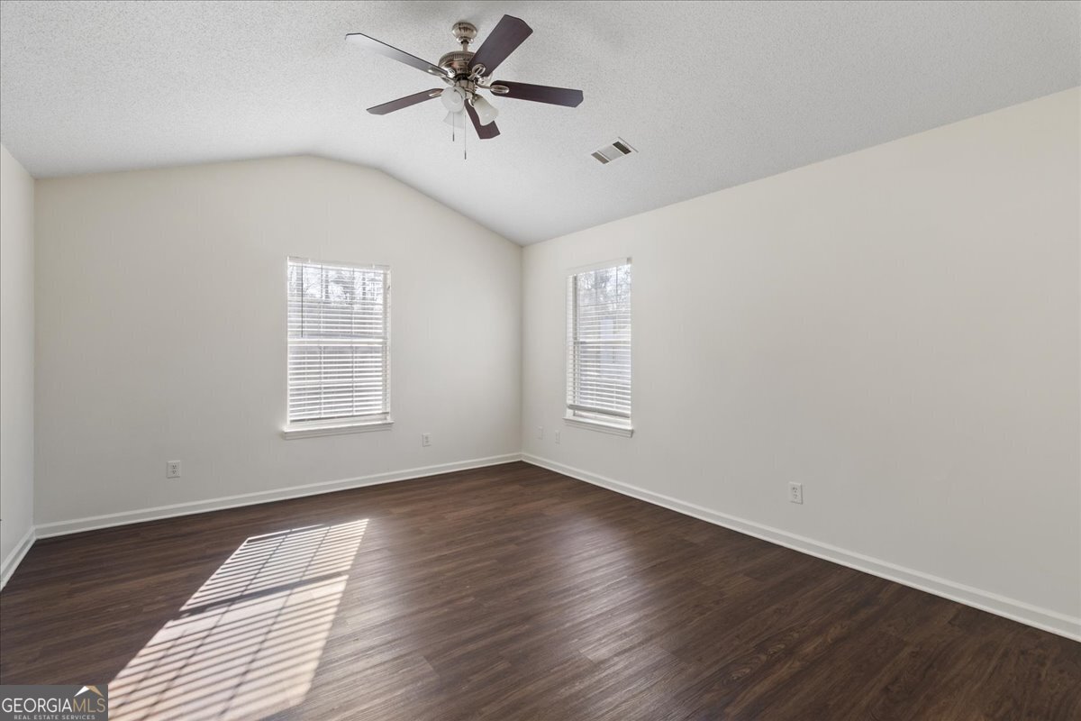 7132 New Dale Road Rex, GA 30273 - Photo 17 of 31 an empty room with wooden floor fan and windows