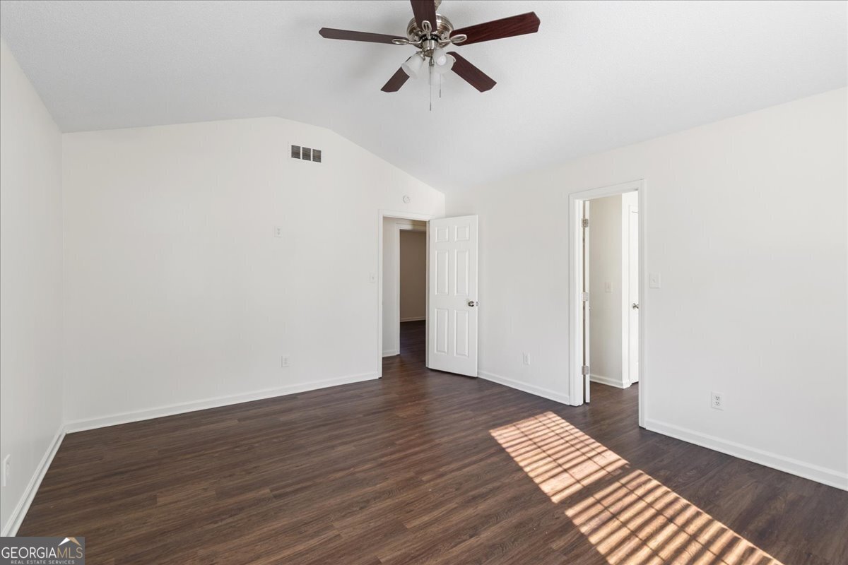 7132 New Dale Road Rex, GA 30273 - Photo 18 of 31 a view of an empty room with wooden floor and a ceiling fan