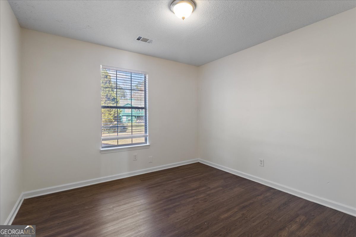 7132 New Dale Road Rex, GA 30273 - Photo 23 of 31 an empty room with wooden floor and windows