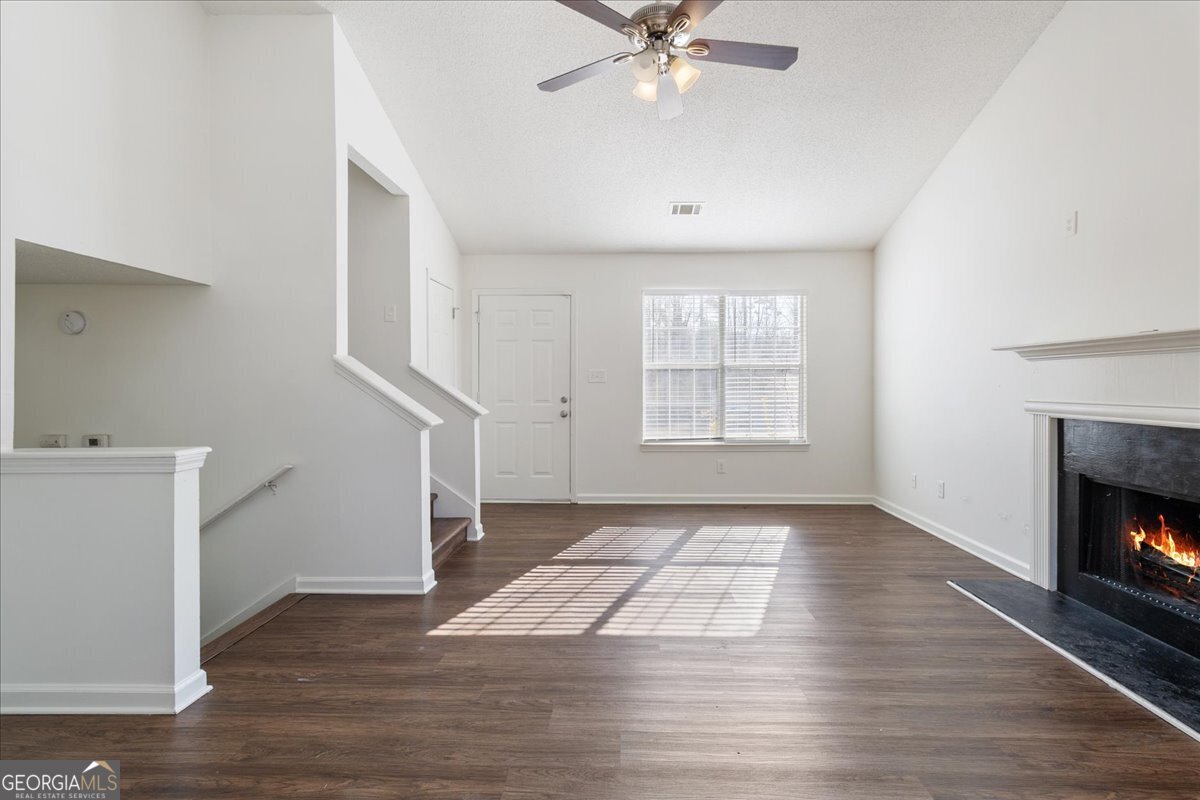 7132 New Dale Road Rex, GA 30273 - Photo 7 of 31 an empty room with wooden floor fan and windows