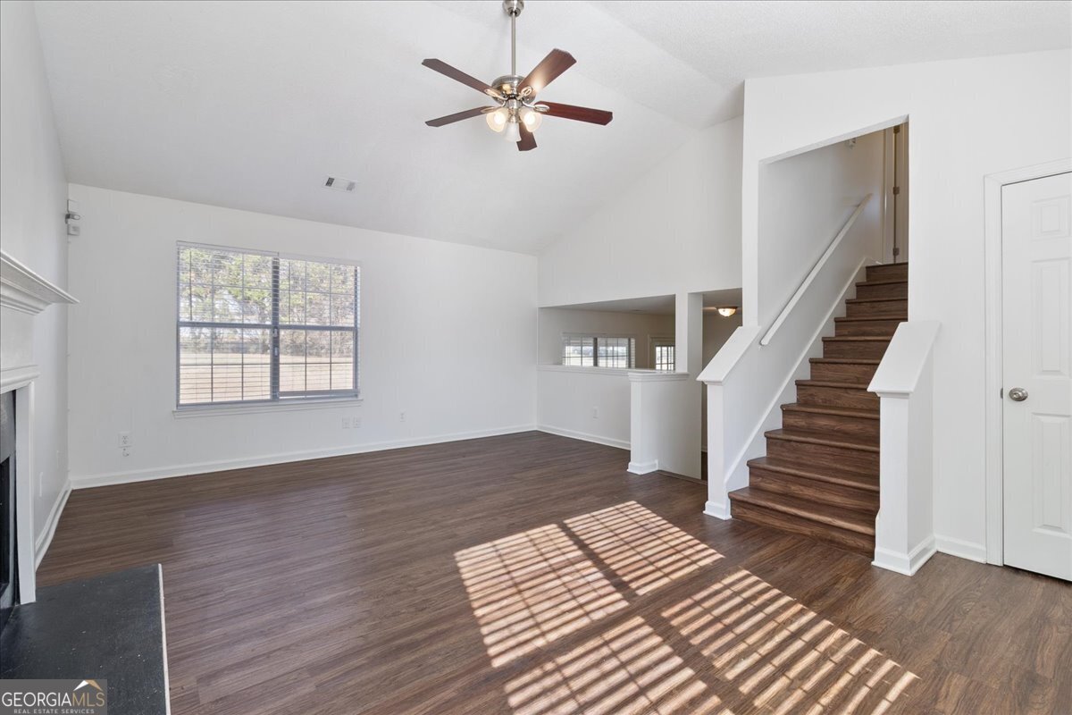 7132 New Dale Road Rex, GA 30273 - Photo 9 of 31 a view of an empty room with wooden floor and a ceiling fan