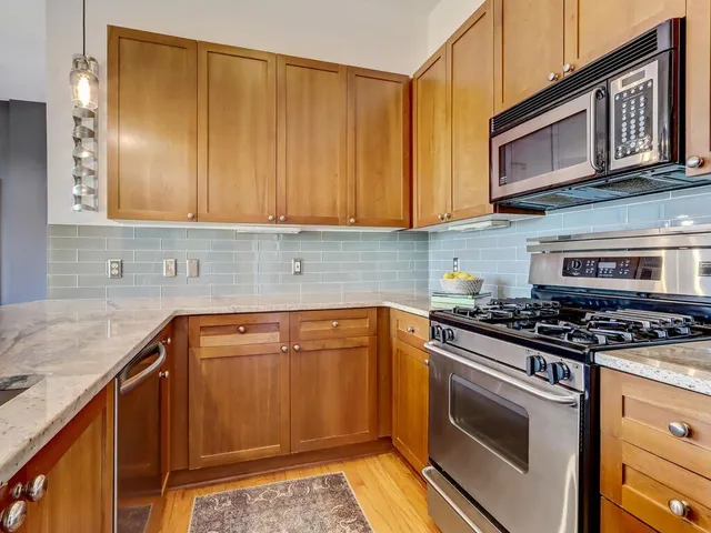 a kitchen with granite countertop cabinets stainless steel appliances and a counter space