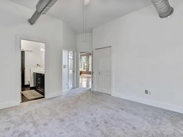 an empty room with windows and closet