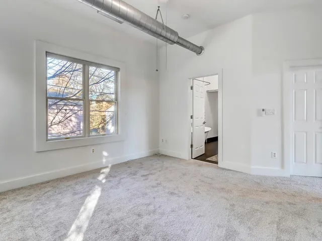 a spacious bathroom with a double vanity sink a large mirror and shower