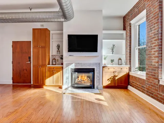 a living room with furniture a flat screen tv and a fireplace