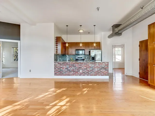 a view of kitchen with stainless steel appliances kitchen island granite countertop a refrigerator and a stove top oven