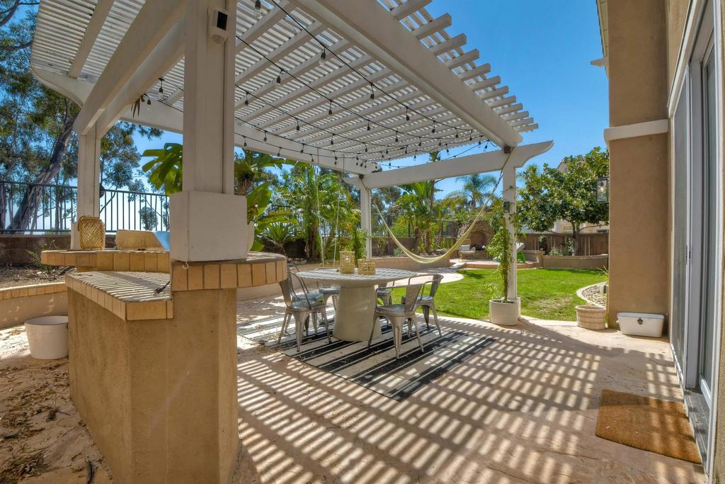 1475 Heritage Lane Encinitas, CA 92024 - Photo 20 of 28 a view of a patio with table and chairs potted plants and floor to ceiling window