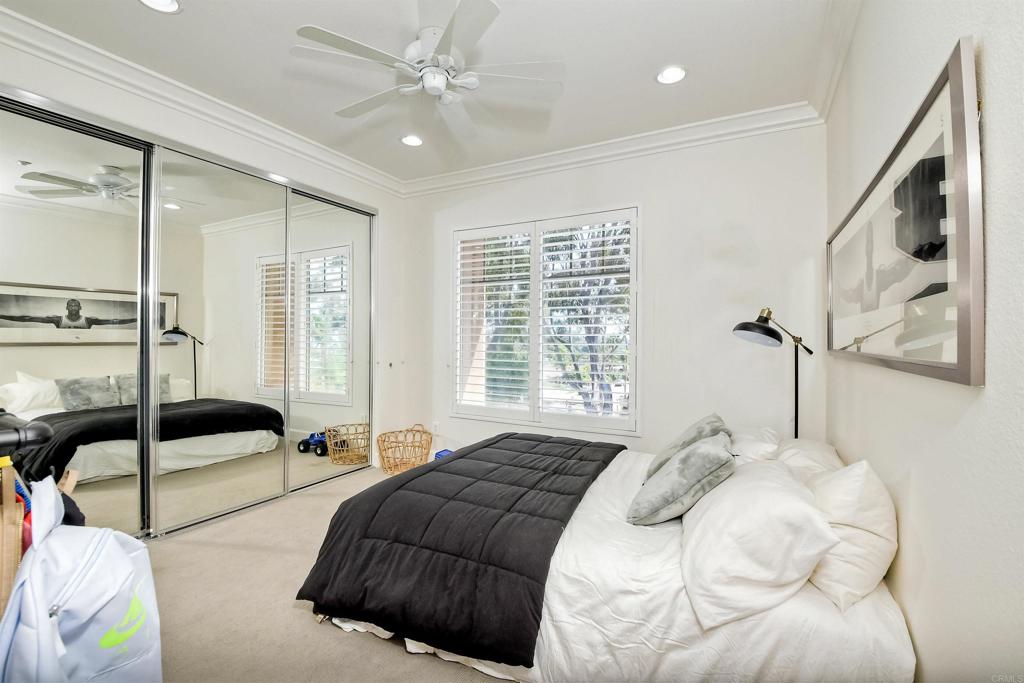 1475 Heritage Lane Encinitas, CA 92024 - Photo 26 of 28 a bedroom with a large bed and a chandelier