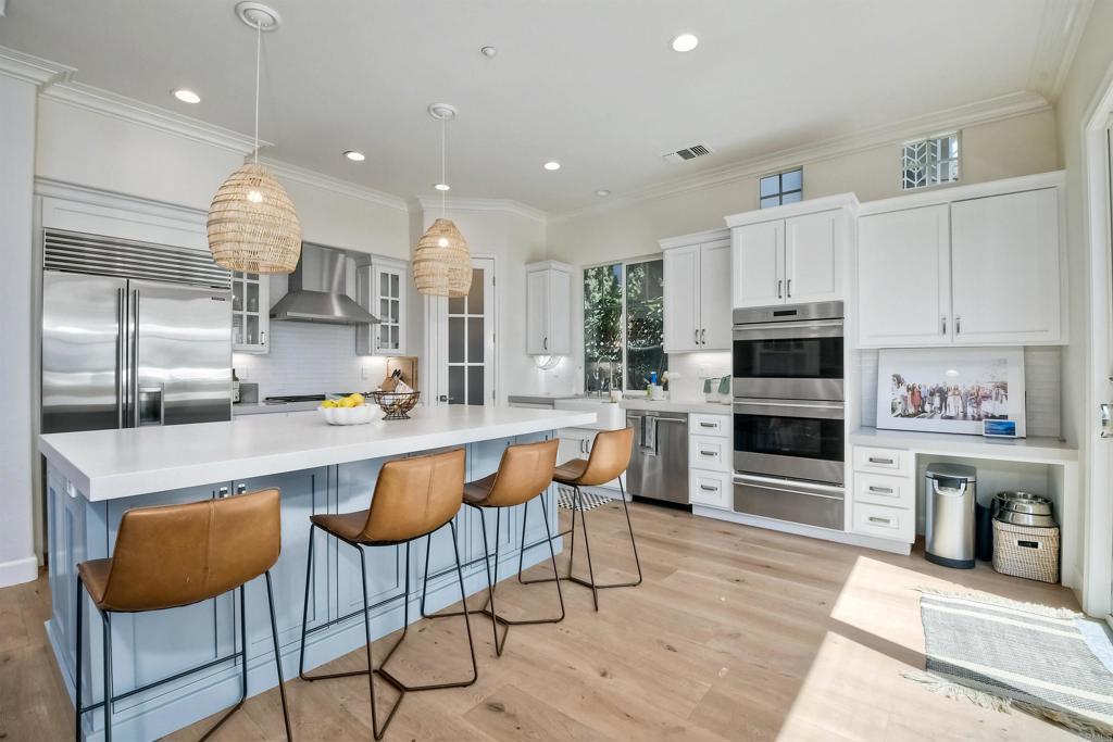 1475 Heritage Lane Encinitas, CA 92024 - Photo 5 of 28 a kitchen with stainless steel appliances granite countertop a stove top oven a sink dishwasher and a refrigerator with wooden floor