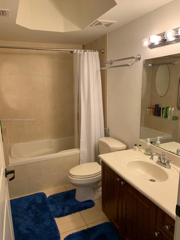 2301 Southwest 27th Avenue, Unit 1200 Miami, FL 33145 - Photo 4 of 9 a bathroom with a sink a toilet a mirror and shower