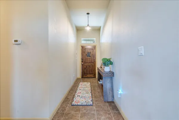 a view of a hallway with wooden floor and a bathroom