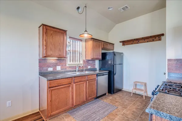 a kitchen with stainless steel appliances granite countertop a sink a stove and refrigerator