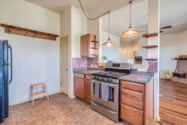 a kitchen with stainless steel appliances granite countertop a stove and a wooden floor