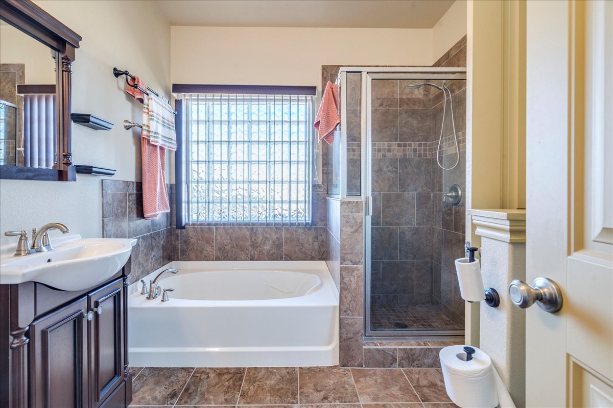 909 County Road 342 Granger, TX 76530 - Photo 21 of 37 Primary bathroom featuring two vanities, garden tub, separate shower & walk in closet