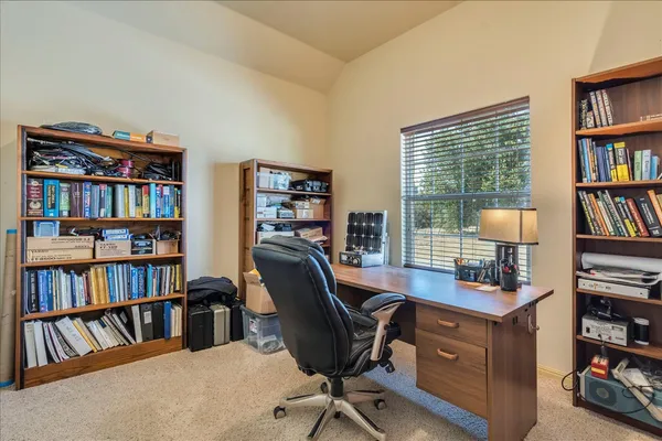 a view of a workspace with bookshelf and a window