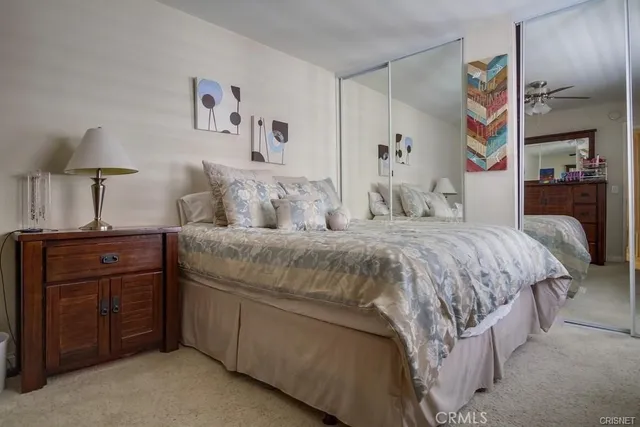a bedroom with a bed and a lamp on dresser