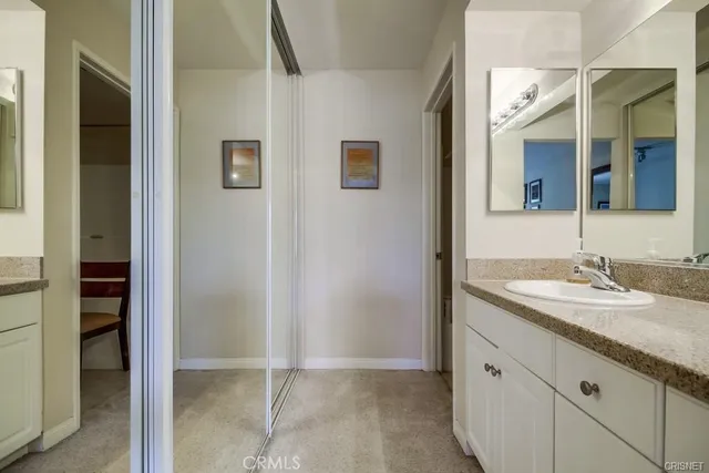 a bathroom with a granite countertop sink and a mirror